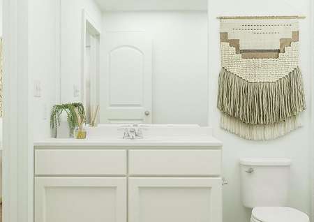 Rendering of
  bathroom with white accents, mirror above sink, and toilet.