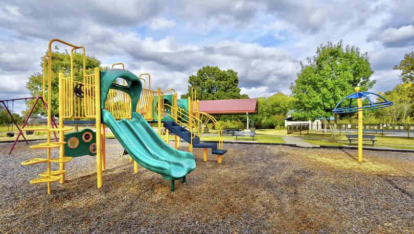 Bunton Creek new home community kid's playground with wood chips and yellow climbing equipment