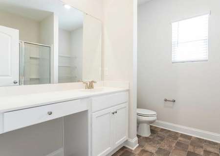 Allatoona master bathroom with tile flooring, white trim, and large vanity with makeup counter