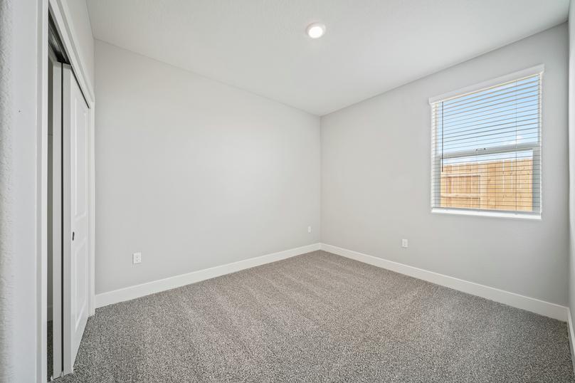 Guest bedroom with a window, tan carpet, and plenty of space for your belongings.