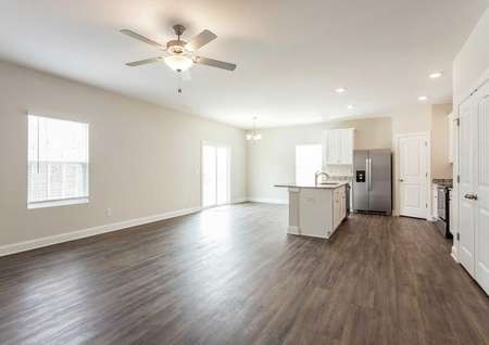 Avery great room with ceiling fan, wood look flooring, and kitchen island