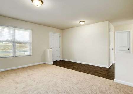 Hartford great room with carpet floors, large windows, and front door