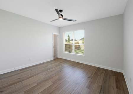 Master bedroom with ceiling fan and plank flooring