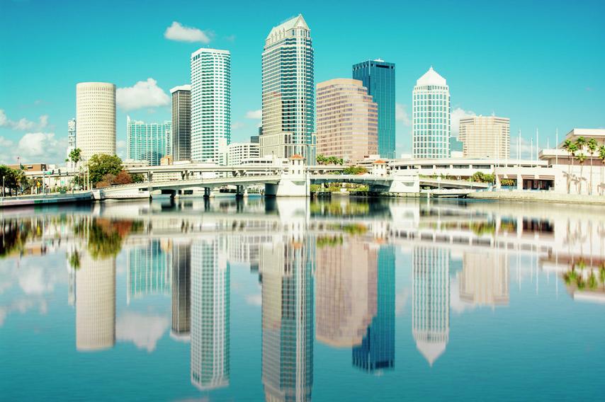 Tampa, Florida skyline with buildings reflecting into the water on a sunny, blue-sky day