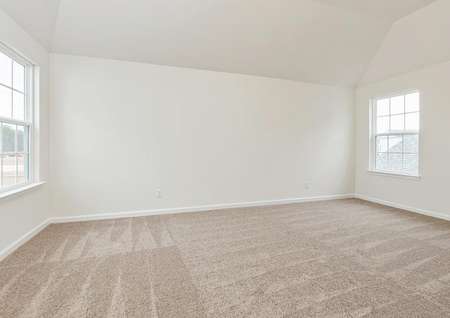 Master bedroom with carpet and large windows.