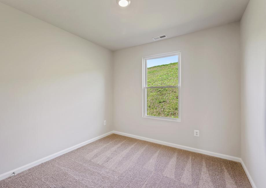 Secondary bedroom with carpet and a window.