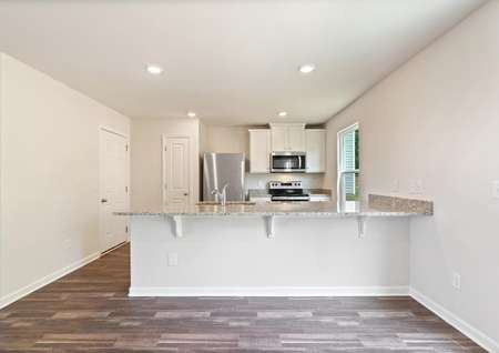 Chef-ready kitchen with gray granite, stainless steel appliances, a breakfast bar and recessed lighting. 